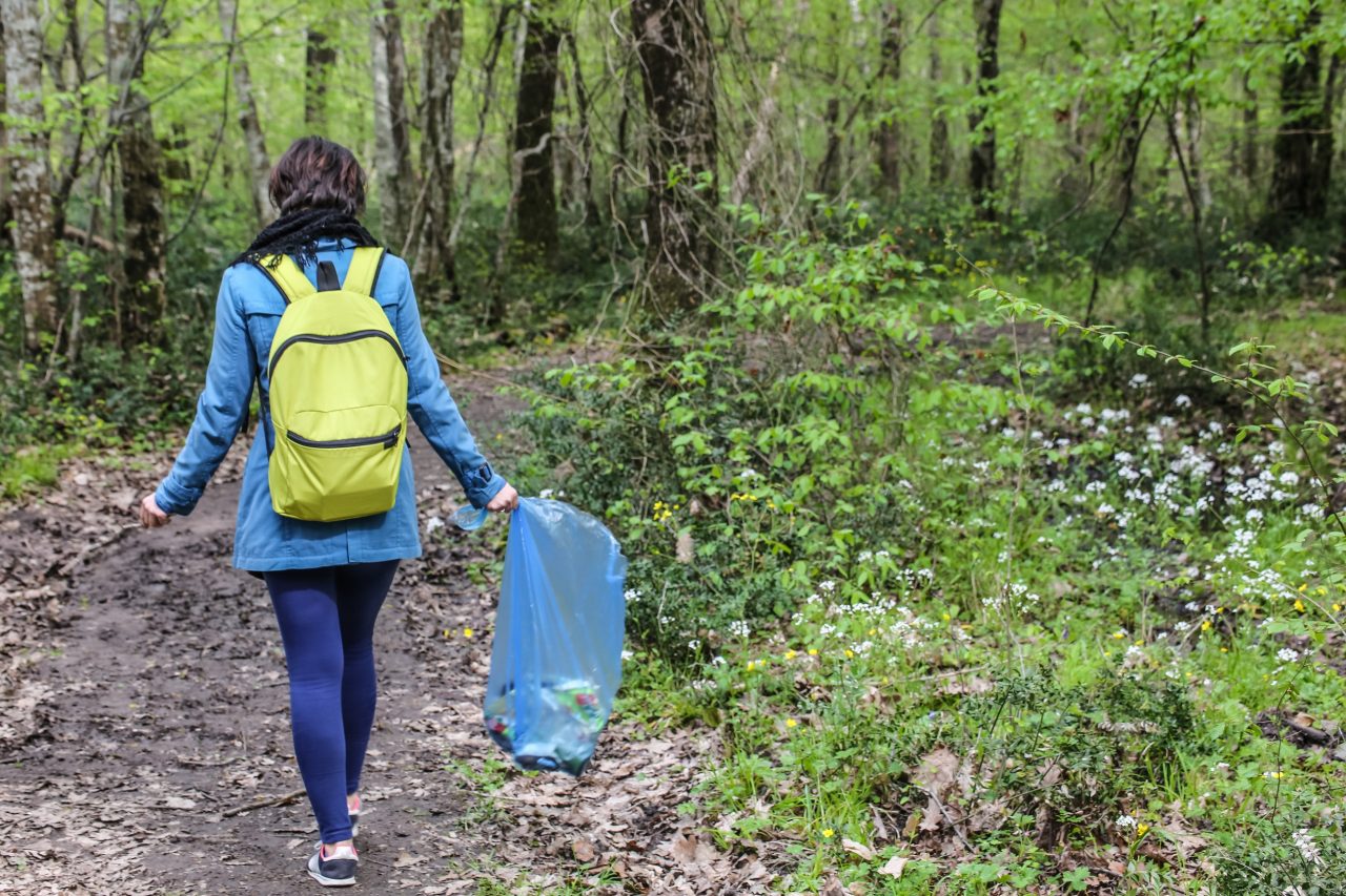 Environmental activist collecting plastic garbages in nature