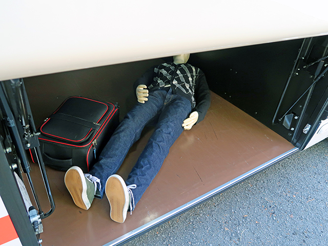 バスのトランクルームに横たわる男性の死体