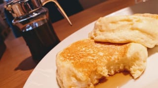 東京都・三鷹市「むさしの森珈琲 三鷹牟礼店」の「“むさしの森珈琲特製”ふわっとろパンケーキ(蜂蜜入りメイプルシロップ付き)」メイプルソースかけた様子