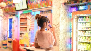 自動販売機の飲み物を飲む女性