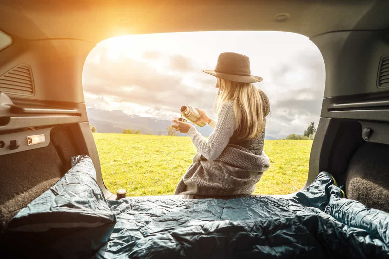 車中で水筒の飲み物を注ぐ