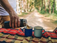 カップに水筒からコーヒーを注ぐ