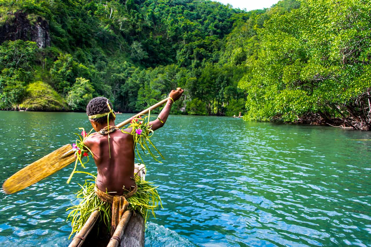 パプアニューギニアの海でボートを漕ぐ人