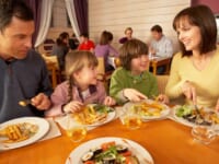 外国人家族がレストランで食事するイメージ