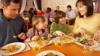 外国人家族がレストランで食事するイメージ