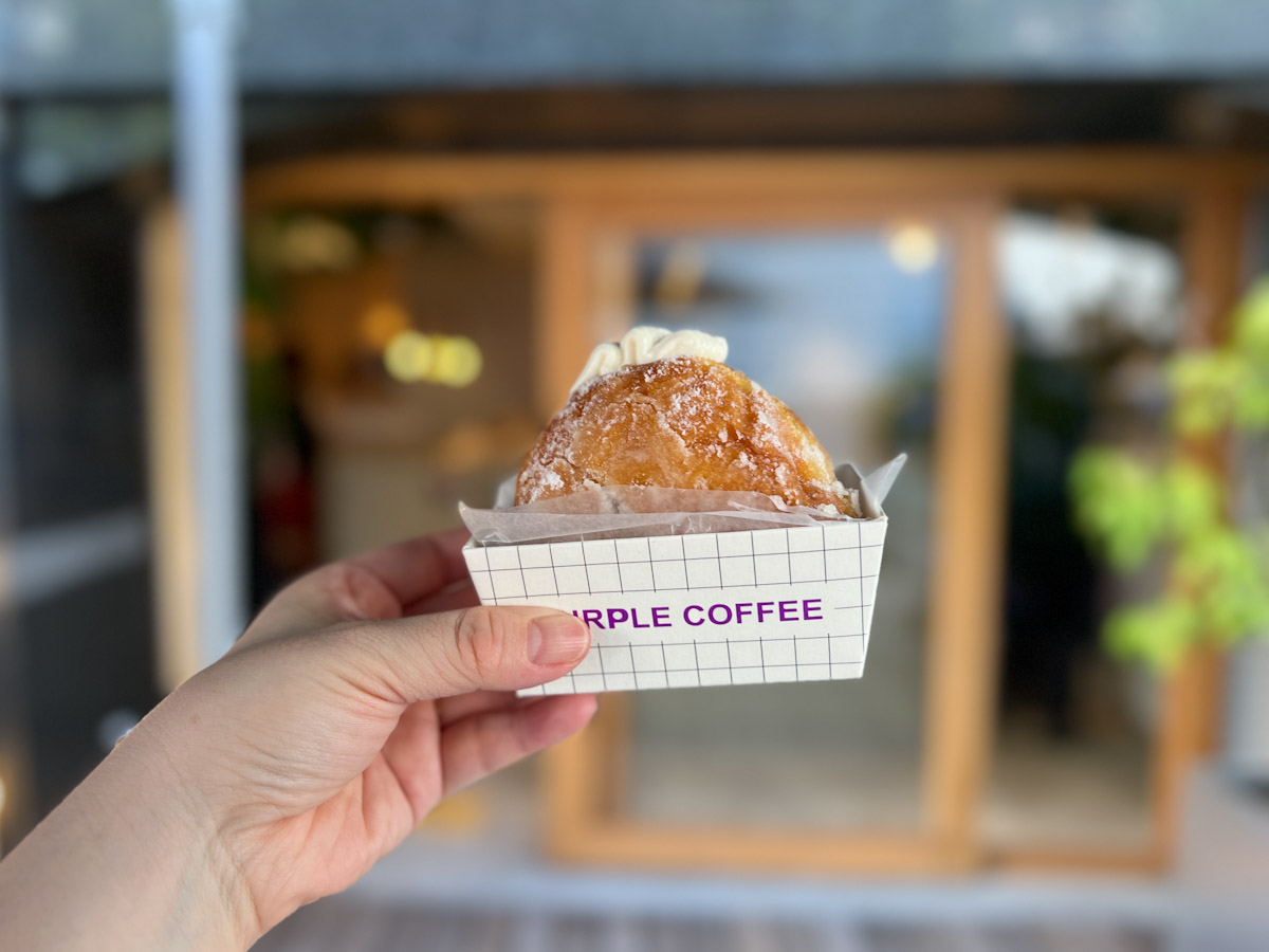 手に持った「PURPLE COFFEE」の揚げドーナツ