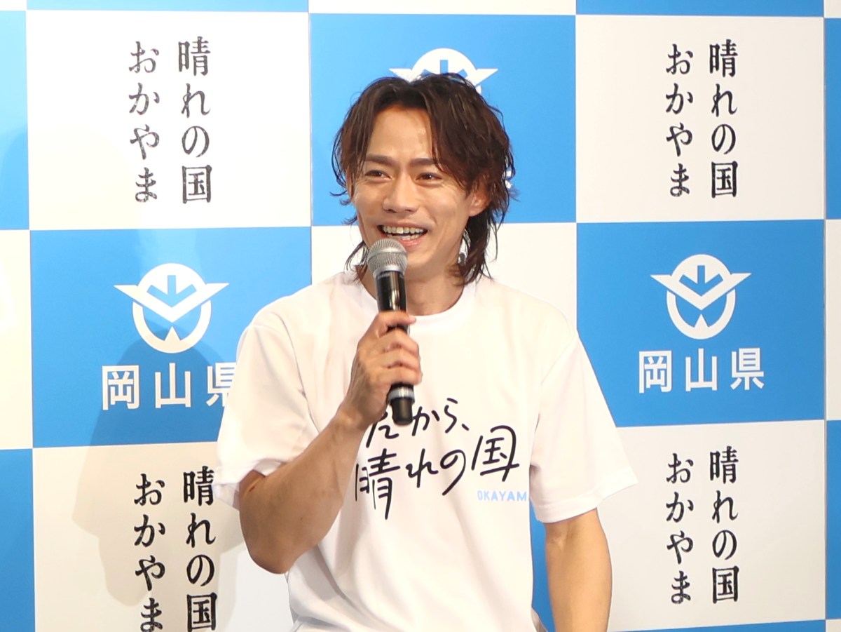 高橋さん（マイクを持って笑顔）