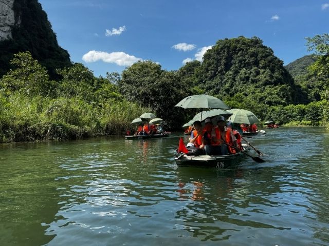 日傘をさしてボートに乗る人々