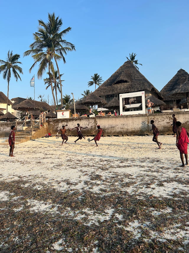 ネグリルの浜辺でサッカーするマサイ族